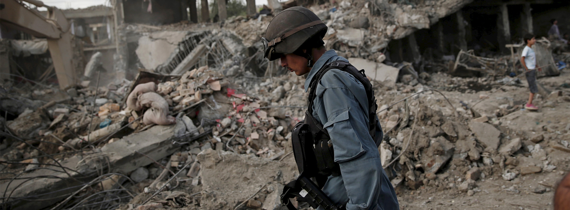 Afghan policeman walks at the site a truck bomb blast in Kabul, August 7, 2015. A truck bomb exploded near an army compound in Kabul on Friday, killing at least 15 people and wounding another 248, police and government officials said, in the first major attack in the Afghan capital since the Taliban announced a new leader. REUTERS/Ahmad Masood