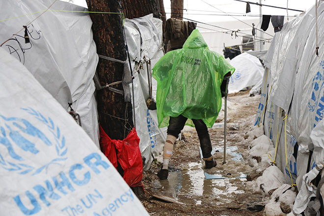 Bild: EU-Hotspot Moria auf Lesbos: Ein Flüchtling bahnt sich auf Krücken den Weg durch Schlamm und Schneematsch zwischen den Zelten, Januar 2017